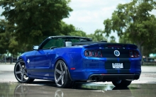 Заряженный синий Ford Mustang Shelby кабриолет на мокром асфальте